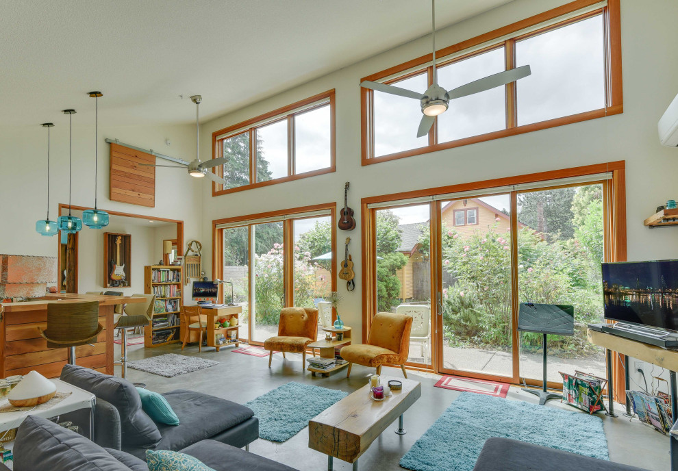 Kleines, Offenes Stilmix Wohnzimmer mit weißer Wandfarbe, Betonboden, Eck-TV, grauem Boden und gewölbter Decke in Portland