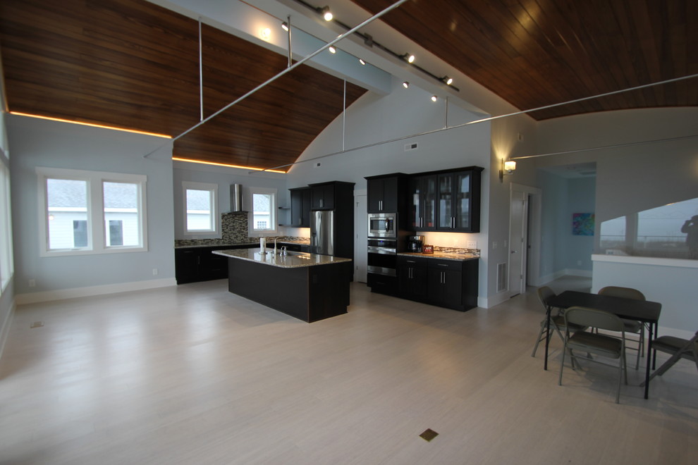 Inspiration for a transitional l-shaped open concept kitchen remodel with an undermount sink, shaker cabinets, dark wood cabinets, granite countertops, brown backsplash and stainless steel appliances