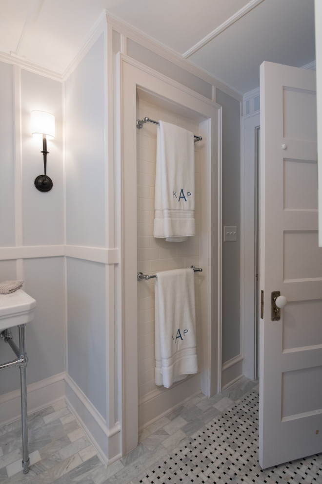 Badezimmer mit freistehender Badewanne, Wandtoilette mit Spülkasten, Marmorboden, Waschtischkonsole und Einzelwaschbecken in Bridgeport