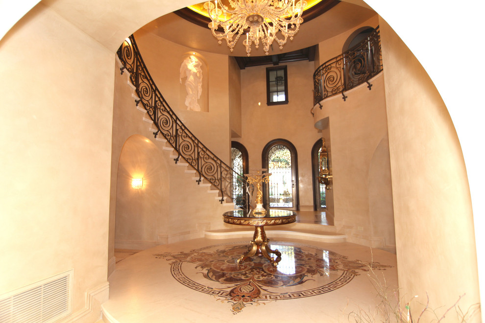 Photo of a large mediterranean foyer in Orange County with beige walls, marble floors, a metal front door and white floor.