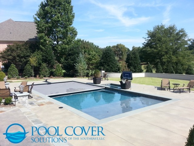 Ejemplo de piscinas y jacuzzis clásicos grandes rectangulares en patio trasero con suelo de hormigón estampado