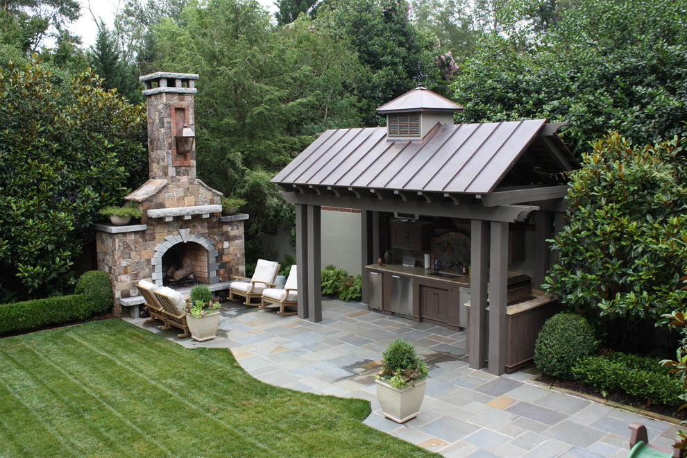 This is an example of a large traditional backyard patio in Other with a fire feature, natural stone pavers and a gazebo/cabana.