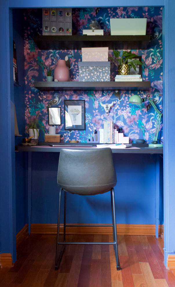 Cette photo montre un bureau atelier exotique de taille moyenne avec un mur bleu, un sol en bois brun et un bureau indépendant.