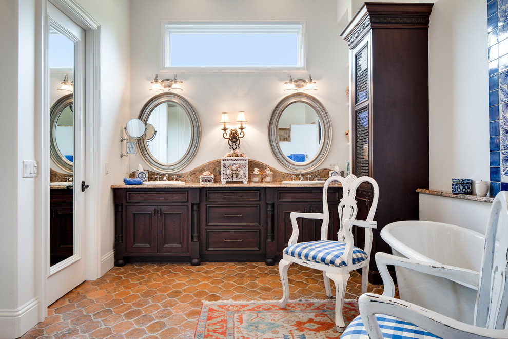 Inspiration for a mediterranean master bathroom in Miami with a drop-in sink, dark wood cabinets, white walls, terra-cotta floors and recessed-panel cabinets.