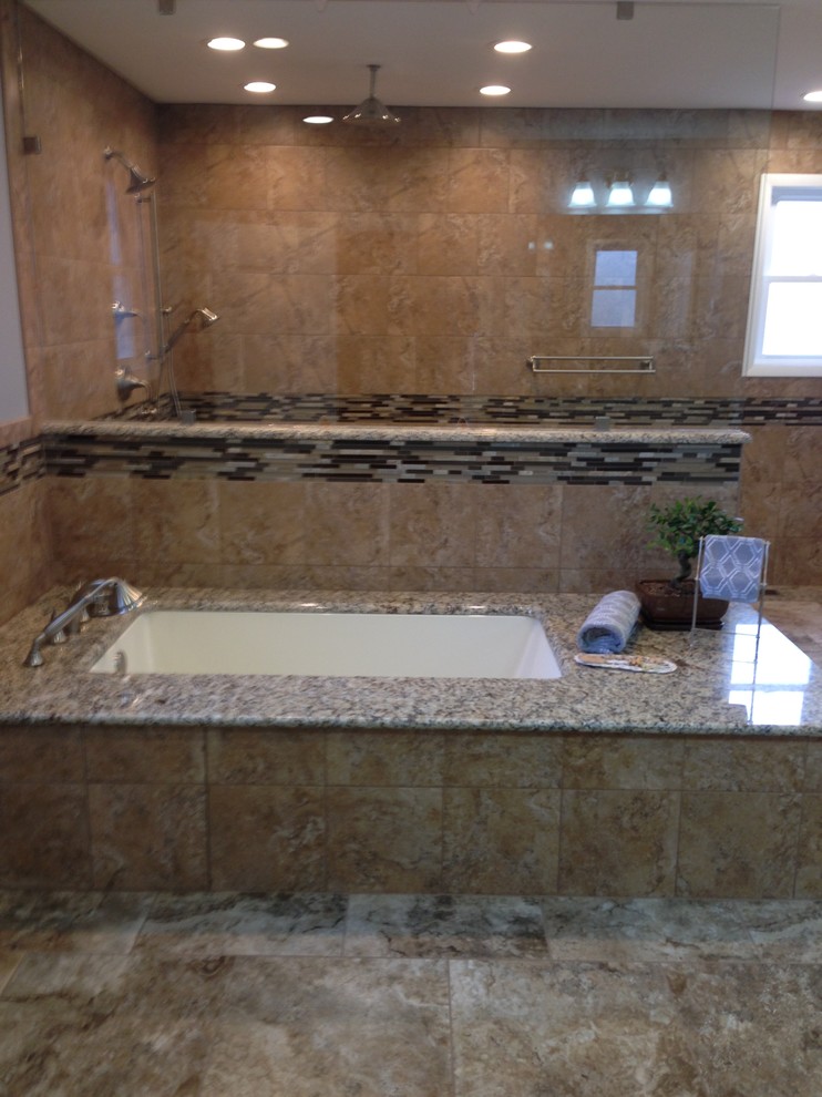 Inspiration for a transitional master brown tile and porcelain tile corner shower remodel with an undermount tub
