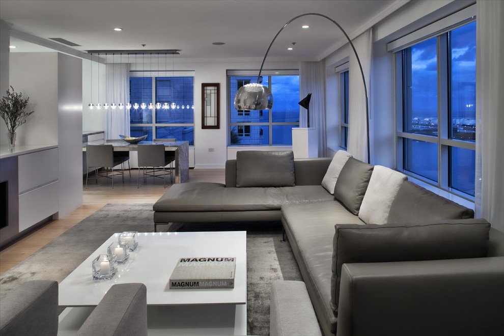 Mid-sized contemporary open concept family room in Chicago with white walls, light hardwood floors, a standard fireplace, a metal fireplace surround and a wall-mounted tv.