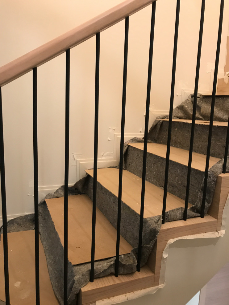 This is an example of a mid-sized industrial wood straight staircase in Moscow with wood risers, metal railing and wallpaper.