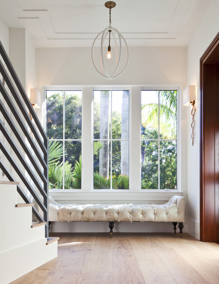 Mid-sized transitional hallway in Miami with white walls and light hardwood floors.