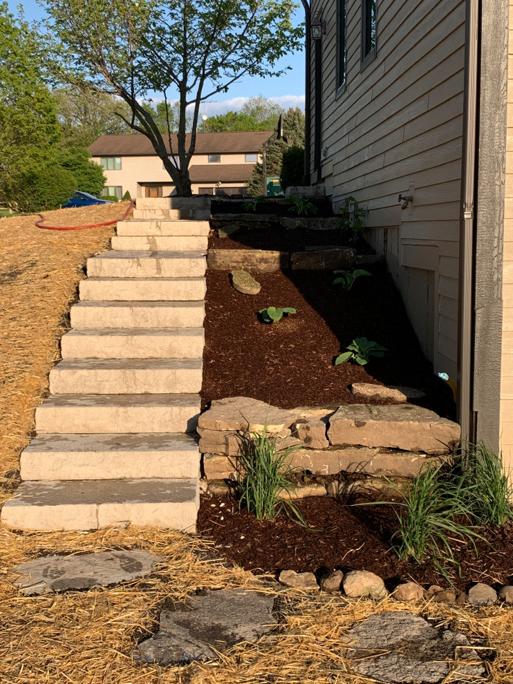 Inspiration for a mid-sized traditional partial sun hillside stone formal garden in Chicago for summer.