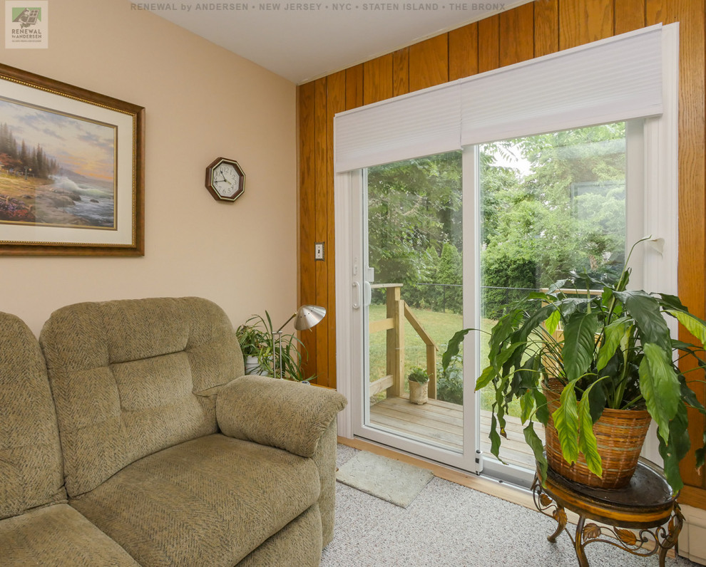 Imagen de sala de estar cerrada pequeña sin chimenea con paredes multicolor, moqueta, televisor en una esquina, suelo beige y panelado