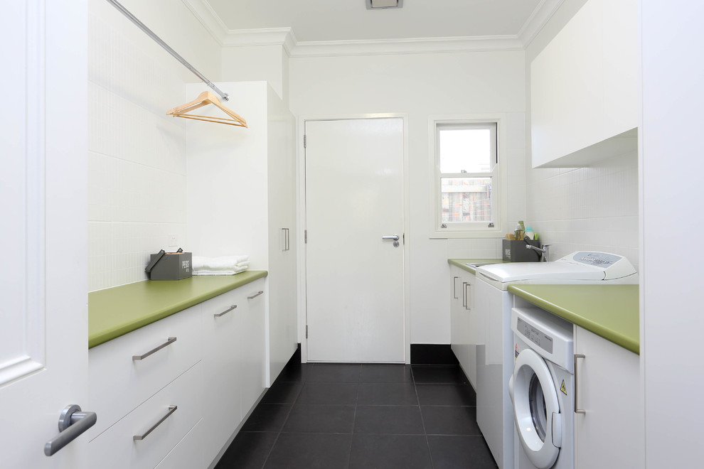 Inspiration for a mid-sized modern galley dedicated laundry room in Brisbane with a drop-in sink, flat-panel cabinets, white cabinets, white walls, ceramic floors, green benchtop and laminate benchtops.