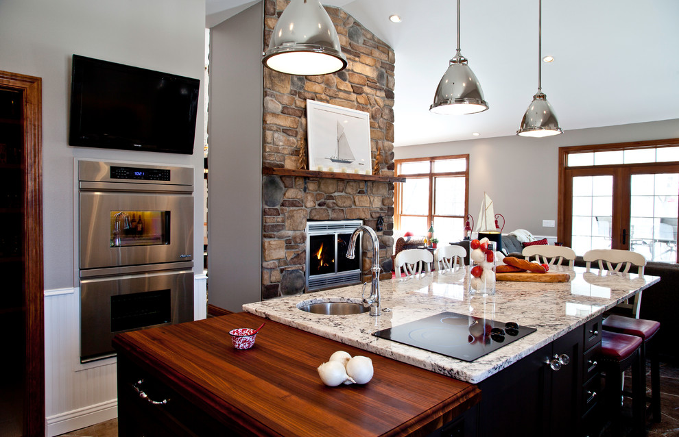 Large transitional u-shaped slate floor and brown floor open concept kitchen photo with granite countertops, two islands, a farmhouse sink, shaker cabinets, white cabinets, yellow backsplash, subway tile backsplash and stainless steel appliances