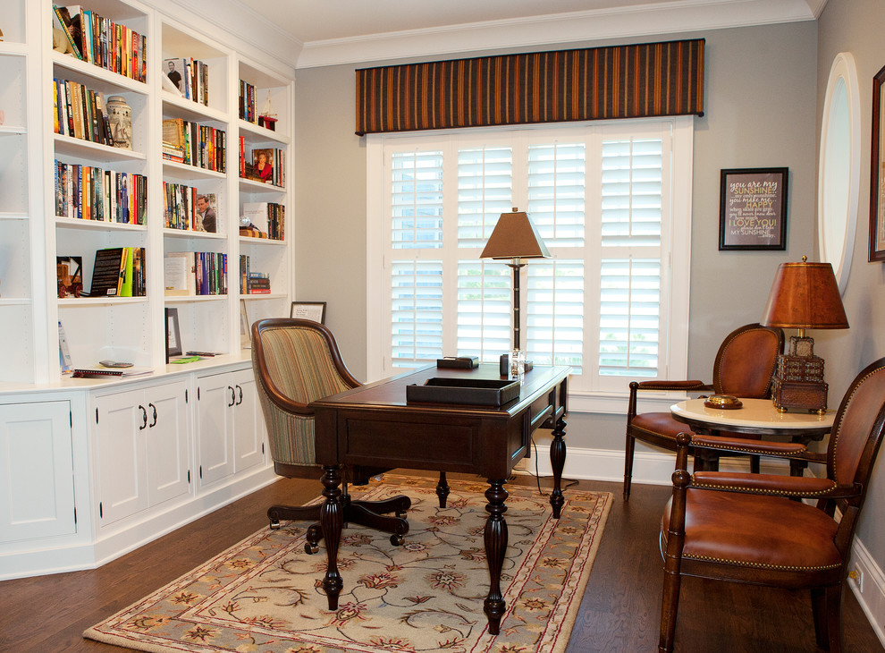 This is an example of a mid-sized traditional study room in Chicago with grey walls, dark hardwood floors, no fireplace, a freestanding desk and brown floor.