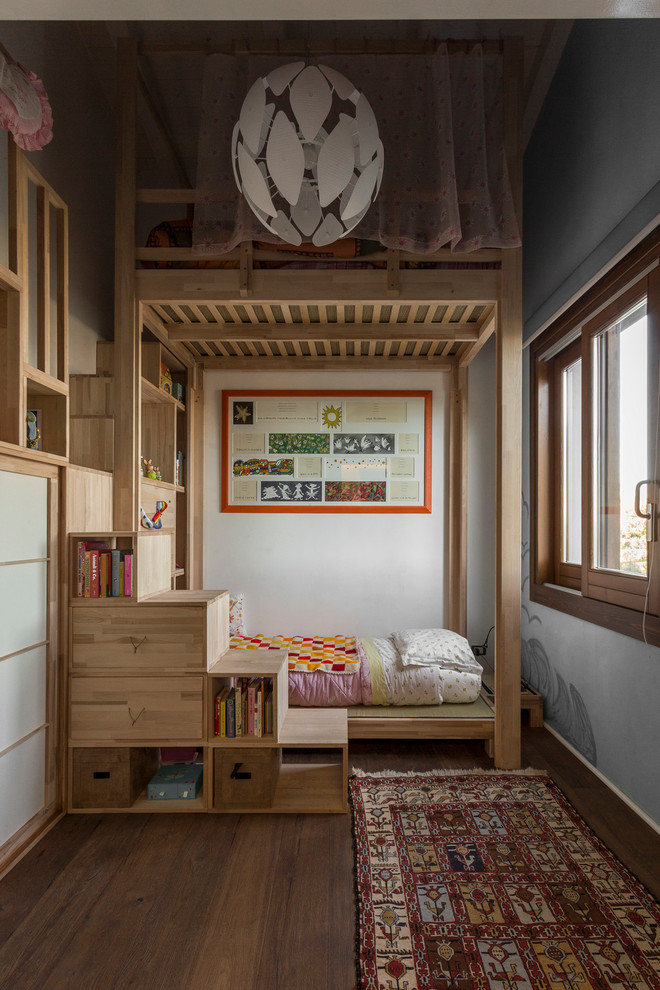 Design ideas for a scandinavian kids' bedroom for kids 4-10 years old and girls in Florence with grey walls, medium hardwood floors and brown floor.