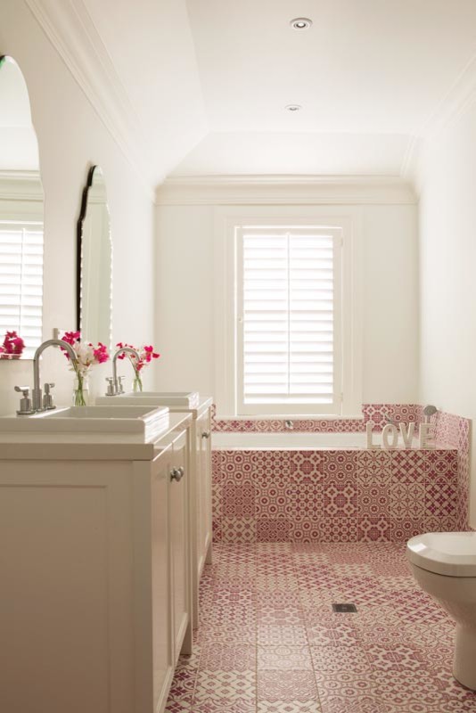 Mid-sized kids bathroom in Sydney with a drop-in sink, shaker cabinets, white cabinets, engineered quartz benchtops, a drop-in tub, a curbless shower, a one-piece toilet, pink tile, ceramic tile, white walls and ceramic floors.
