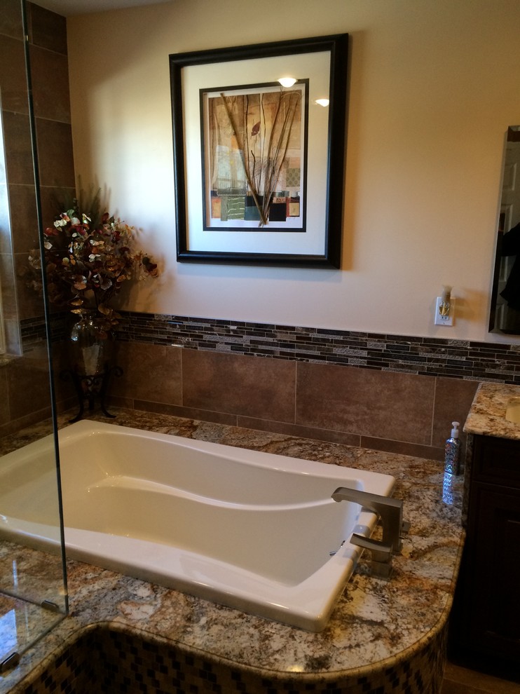 Design ideas for a mid-sized transitional master bathroom in Philadelphia with an undermount sink, recessed-panel cabinets, dark wood cabinets, granite benchtops, a drop-in tub, a double shower, a two-piece toilet, beige tile, porcelain tile, beige walls and porcelain floors.