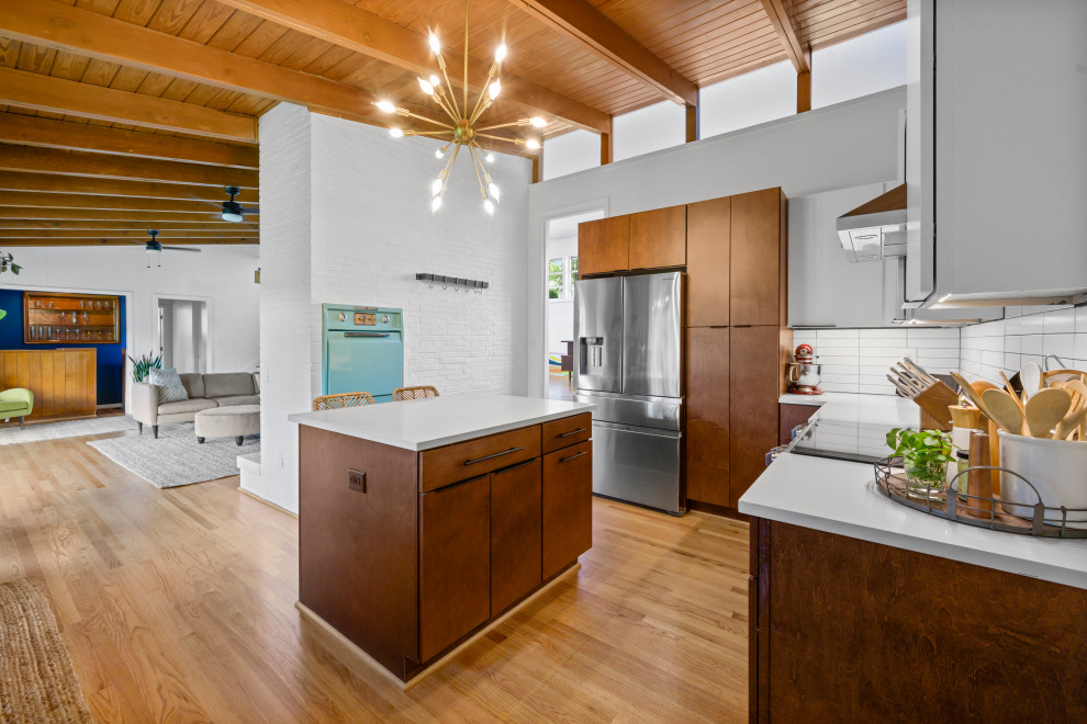 Photo of a mid-sized midcentury u-shaped separate kitchen in Birmingham with an undermount sink, flat-panel cabinets, medium wood cabinets, quartz benchtops, blue splashback, ceramic splashback, stainless steel appliances, light hardwood floors, with island, brown floor, white benchtop and exposed beam.