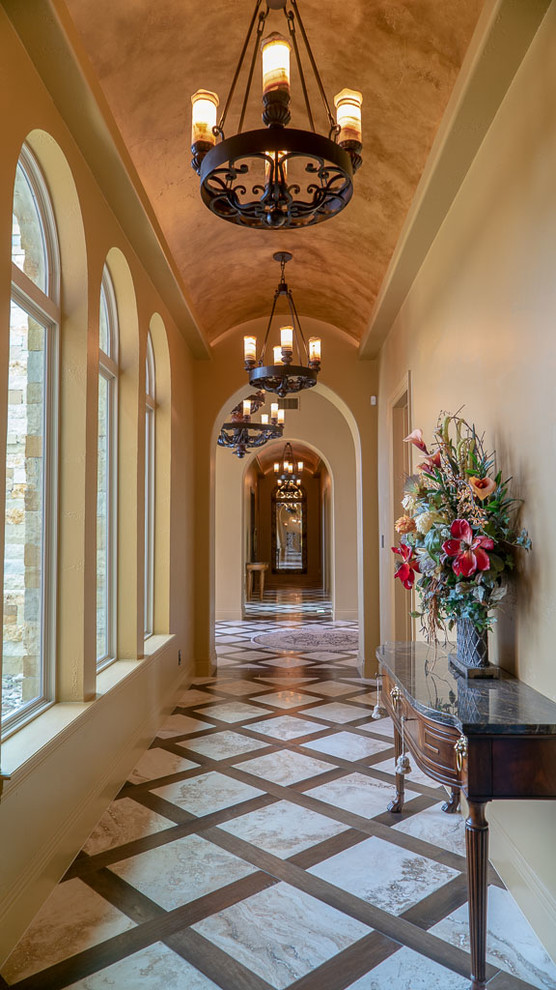 This is an example of a mediterranean hallway in Austin with beige walls and beige floor.