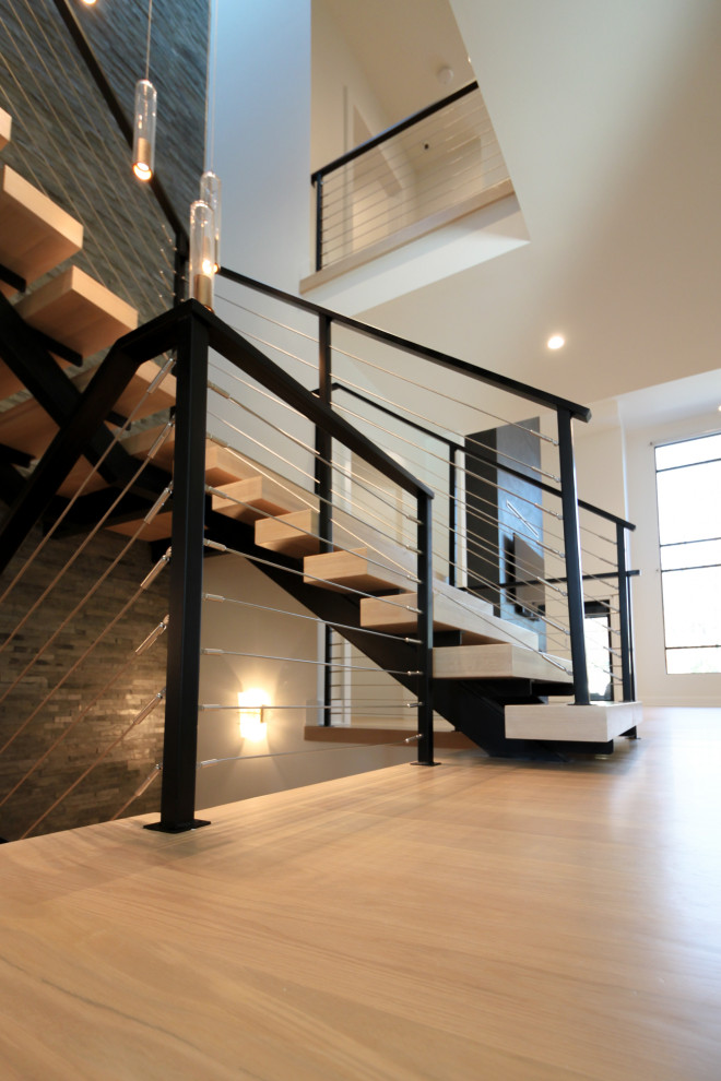 Свежая идея для дизайна: большая лестница на больцах в стиле фьюжн с деревянными ступенями, металлическими перилами и кирпичными стенами - отличное фото интерьера