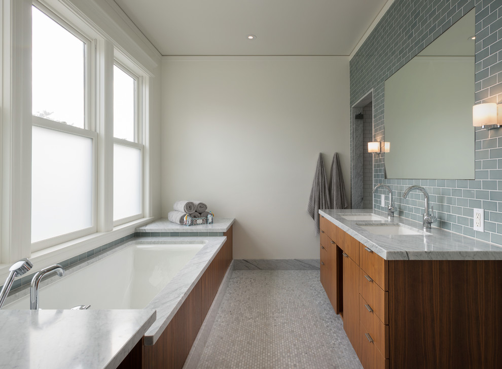 Design ideas for a contemporary bathroom in San Francisco with an undermount sink, flat-panel cabinets, medium wood cabinets, an undermount tub, gray tile, subway tile, mosaic tile floors and grey benchtops.