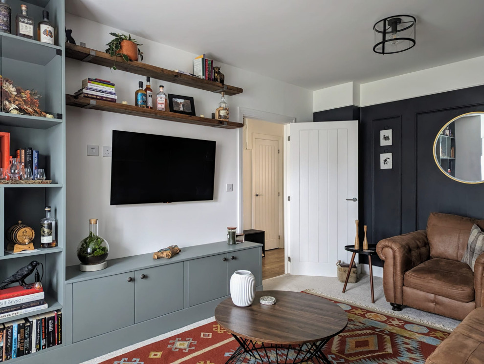 Photo of a medium sized eclectic formal and grey and brown enclosed living room feature wall in Cambridgeshire with black walls, carpet, a wall mounted tv, beige floors and wainscoting.
