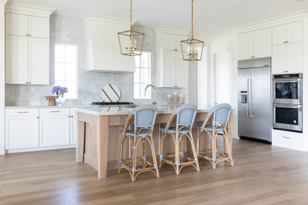 Example of a huge transitional light wood floor kitchen design in Dallas with shaker cabinets, white cabinets, quartzite countertops, stainless steel appliances, an island and beige countertops