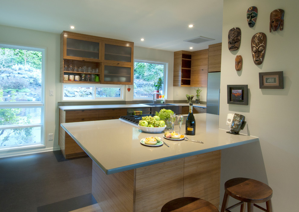 Inspiration for a small midcentury kitchen in Seattle with a farmhouse sink, glass-front cabinets, light wood cabinets, quartz benchtops, stainless steel appliances and grey benchtop.