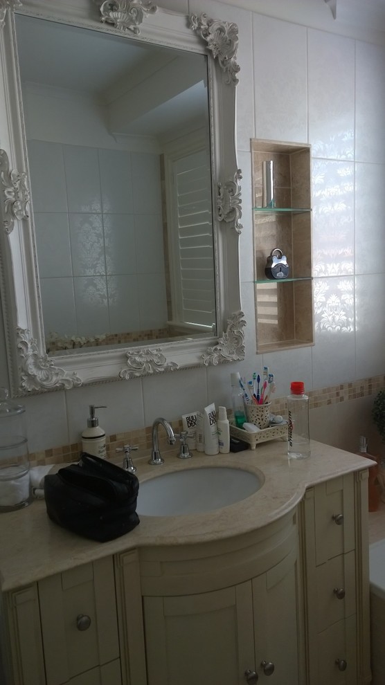 Mid-sized mediterranean bathroom in Melbourne with an undermount sink, furniture-like cabinets, beige cabinets, a corner tub, a corner shower, multi-coloured tile, porcelain tile, multi-coloured walls and porcelain floors.