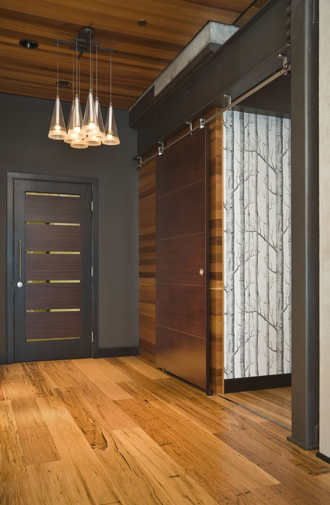 Inspiration for a contemporary entryway in Portland with black walls, medium hardwood floors and a single front door.