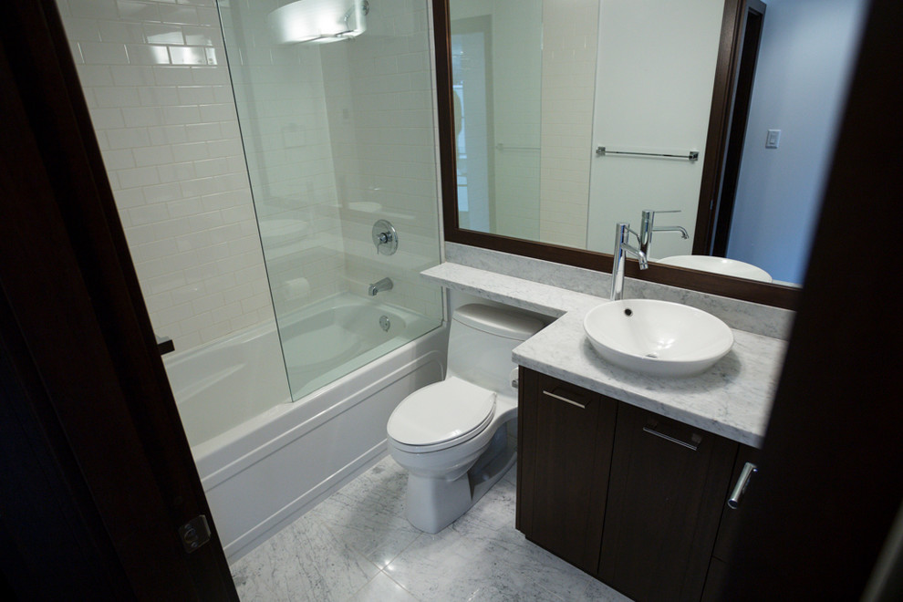 This is an example of a mid-sized modern master bathroom in Vancouver with brown cabinets, marble benchtops, white tile, white walls, marble floors, flat-panel cabinets, a freestanding tub, an alcove shower, a two-piece toilet, stone tile and a vessel sink.