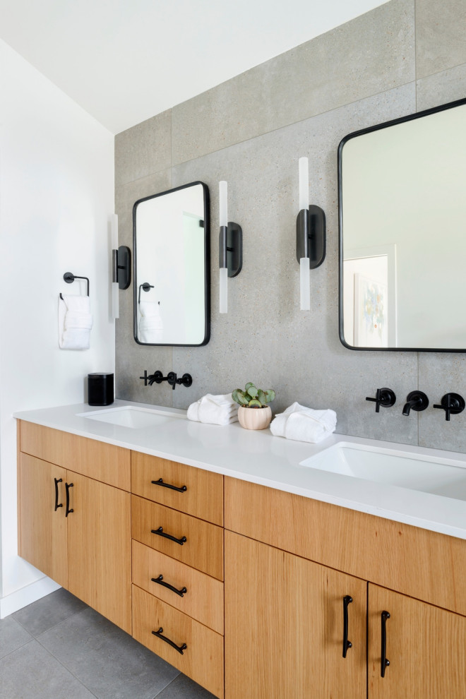 Photo of a medium sized contemporary ensuite bathroom in Seattle with flat-panel cabinets, light wood cabinets, an alcove bath, a built-in shower, a two-piece toilet, grey tiles, porcelain tiles, grey walls, porcelain flooring, a submerged sink, engineered stone worktops, grey floors, an open shower, white worktops, an enclosed toilet, double sinks, a floating vanity unit and a vaulted ceiling.