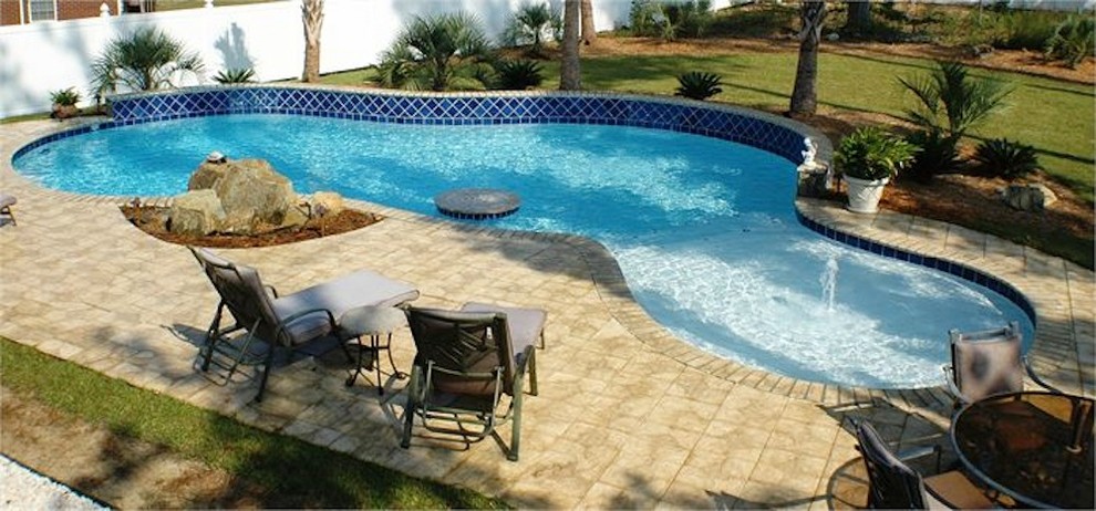 Example of a mid-sized backyard stone and rectangular natural hot tub design