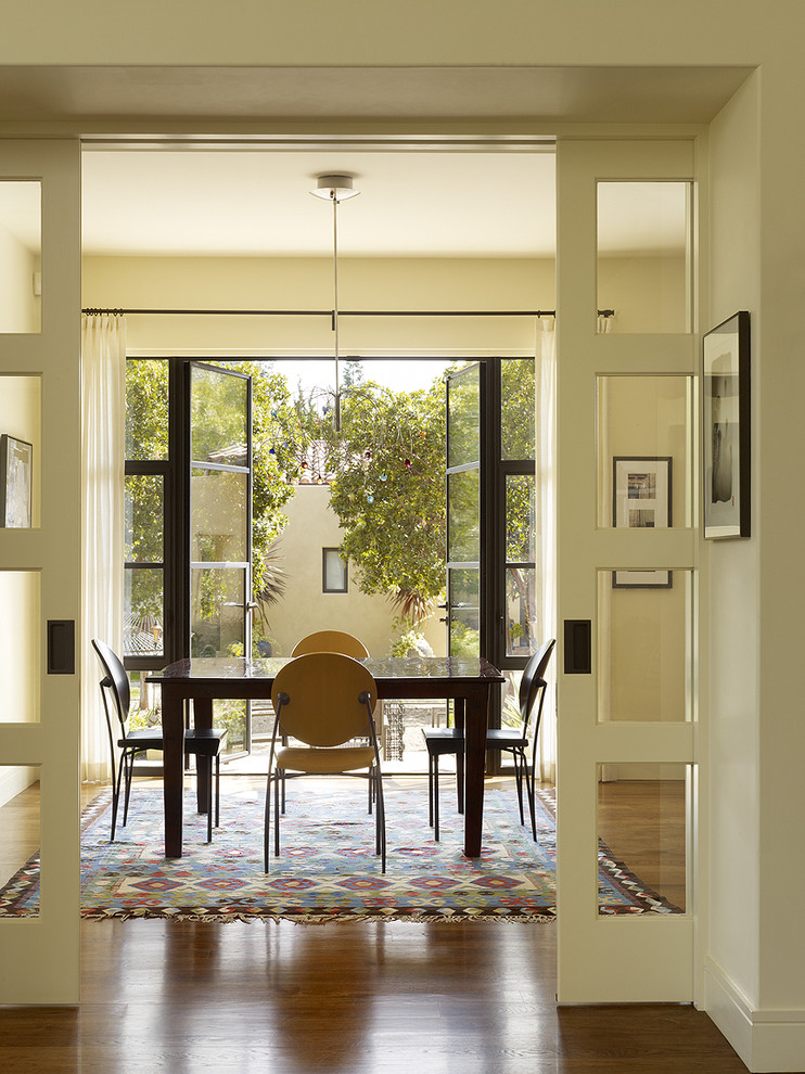 Transitional dining room in San Francisco with brown floor.