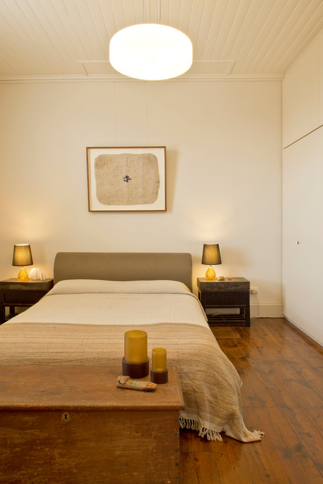 Photo of a large traditional guest bedroom in Sydney with white walls and dark hardwood floors.