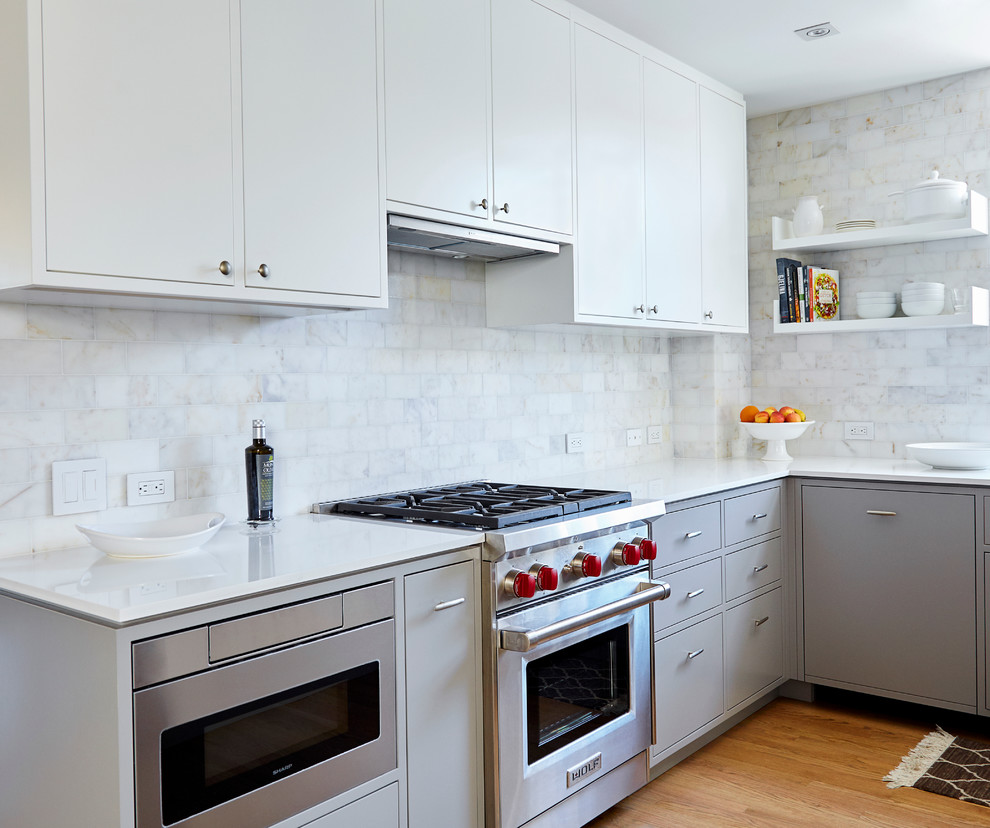 This is an example of a mid-sized contemporary u-shaped eat-in kitchen in New York with an undermount sink, flat-panel cabinets, grey cabinets, quartz benchtops, white splashback, stone tile splashback, stainless steel appliances, medium hardwood floors and no island.
