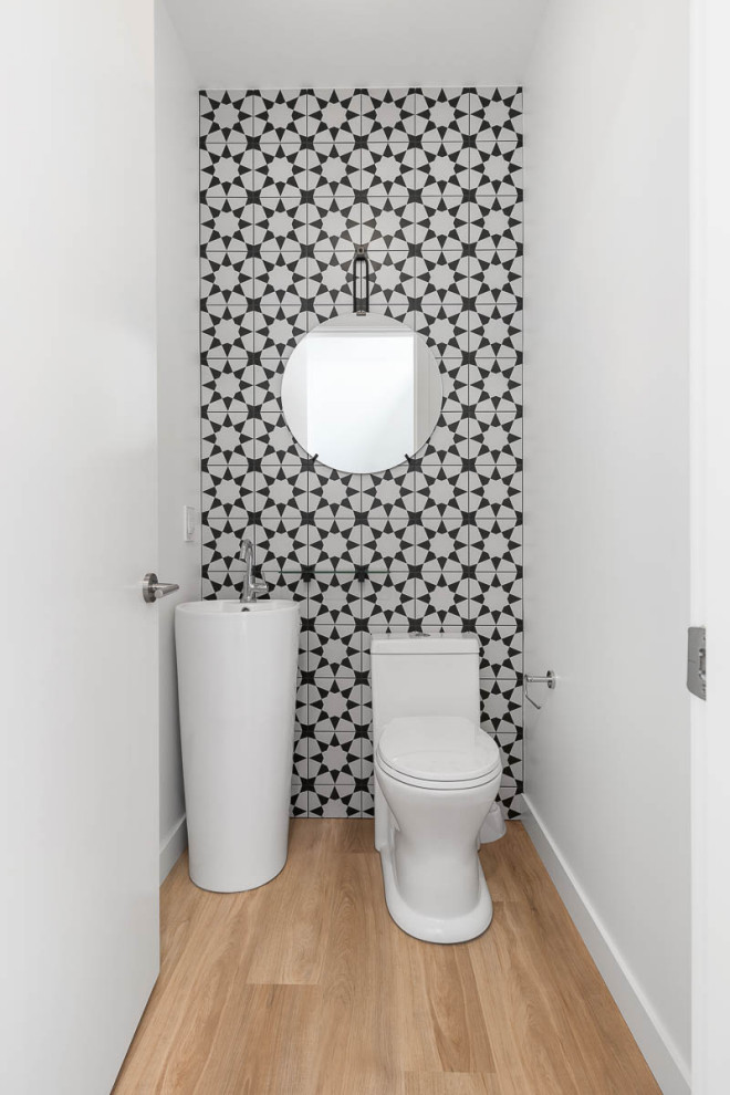 Свежая идея для дизайна: маленький туалет в стиле модернизм с унитазом-моноблоком, черно-белой плиткой, керамической плиткой, белыми стенами, полом из винила, раковиной с пьедесталом и коричневым полом для на участке и в саду - отличное фото интерьера