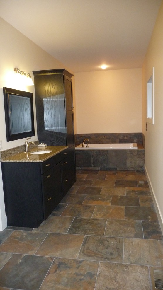 Inspiration for a transitional master multicolored tile and ceramic tile ceramic tile drop-in bathtub remodel with flat-panel cabinets, dark wood cabinets, a two-piece toilet, white walls, an undermount sink and granite countertops