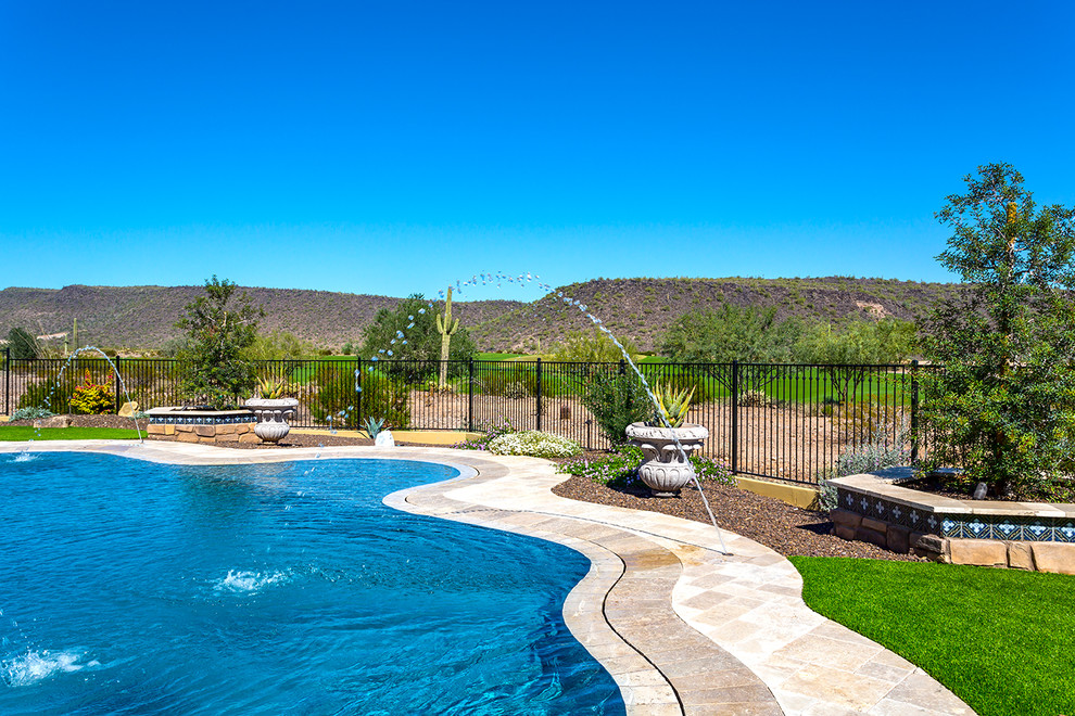 Large tuscan backyard stone and custom-shaped natural pool photo in Phoenix