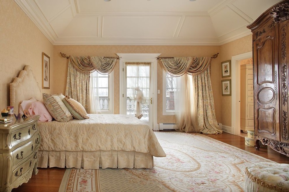 Inspiration for an expansive traditional master bedroom in New York with beige walls, medium hardwood floors, a standard fireplace, a stone fireplace surround and brown floor.