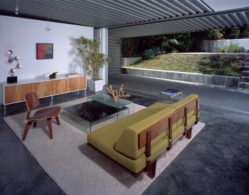 This is an example of a midcentury living room in New Orleans with concrete floors.