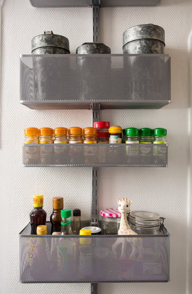 Inspiration for a small eclectic galley ceramic tile enclosed kitchen remodel with flat-panel cabinets, white cabinets, stainless steel countertops, white backsplash, ceramic backsplash, white appliances and no island