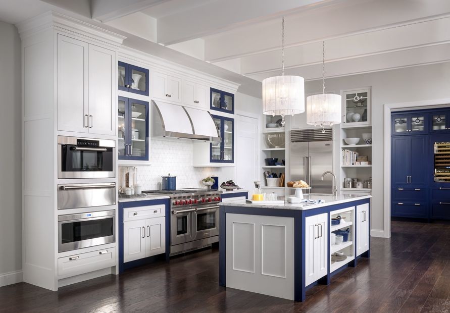 Large traditional u-shaped separate kitchen in New Orleans with recessed-panel cabinets, white cabinets, quartzite benchtops, white splashback, an undermount sink, ceramic splashback, stainless steel appliances, dark hardwood floors and multiple islands.