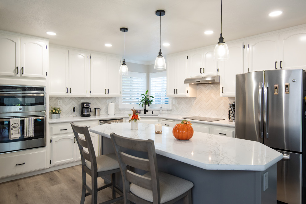 Design ideas for a modern eat-in kitchen in Sacramento with an undermount sink, white cabinets, quartz benchtops, white splashback, ceramic splashback, stainless steel appliances, with island and white benchtop.
