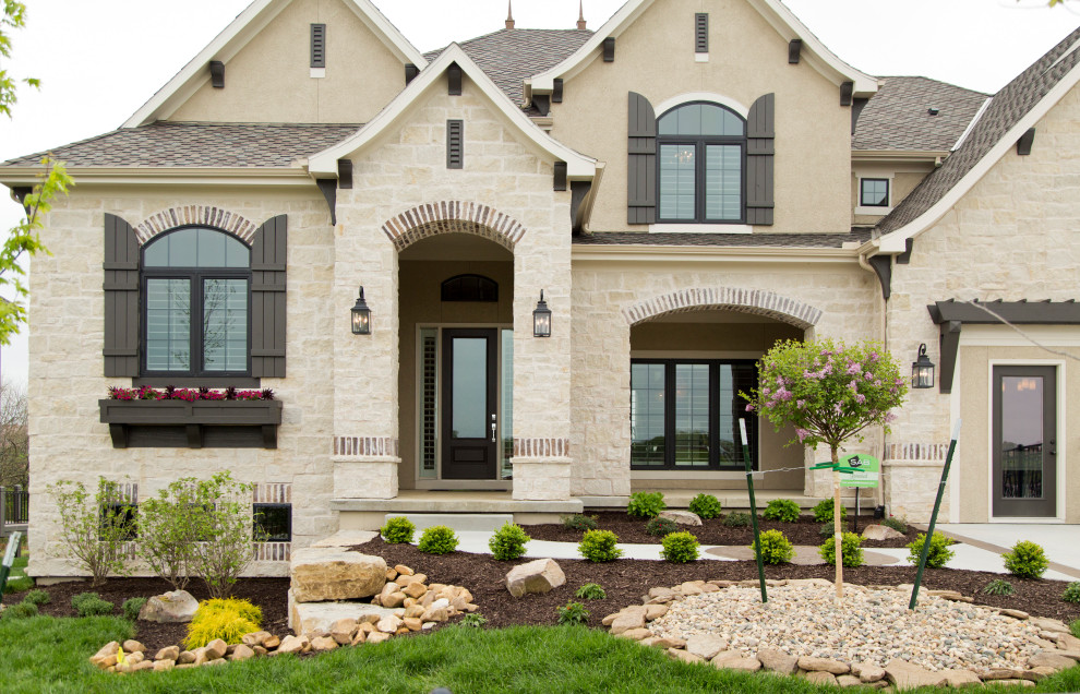 Inspiration for a large two-storey beige house exterior in Kansas City with mixed siding and a shingle roof.