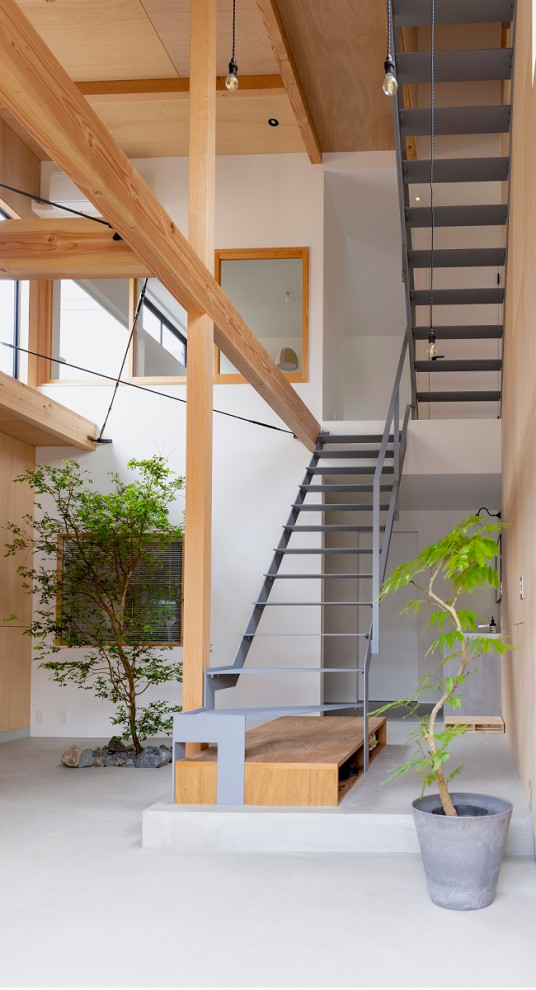 Photo of a mid-sized asian metal floating staircase in Kyoto with metal risers, metal railing and wood walls.