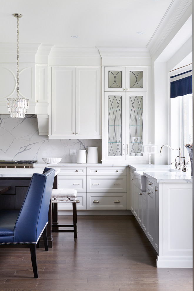 Mid-sized transitional u-shaped medium tone wood floor enclosed kitchen photo in Toronto with a farmhouse sink, recessed-panel cabinets, white cabinets, white backsplash and an island