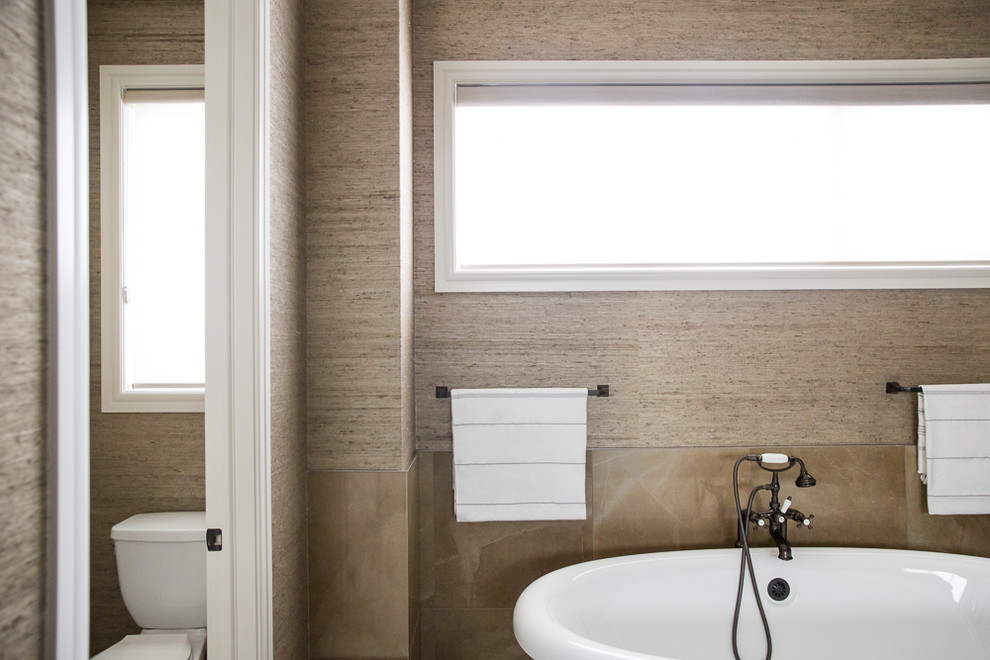 Inspiration for a large traditional master bathroom in Vancouver with shaker cabinets, dark wood cabinets, a freestanding tub, an alcove shower, brown walls, an undermount sink, marble benchtops, brown floor and a hinged shower door.
