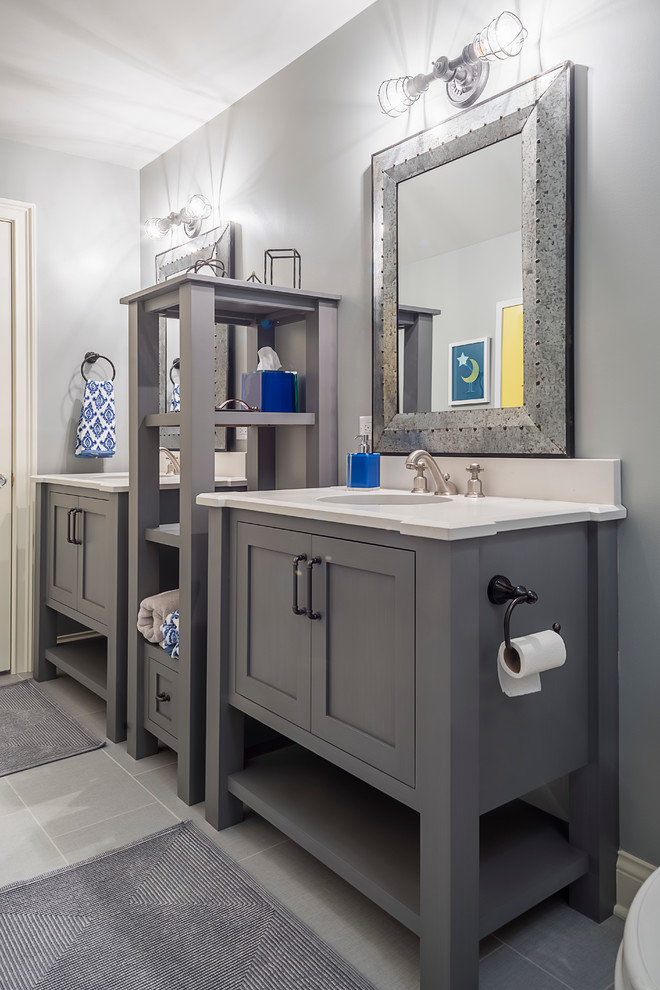 Inspiration for a mid-sized eclectic kids bathroom in Chicago with furniture-like cabinets, grey cabinets, an alcove shower, a two-piece toilet, gray tile, porcelain tile, grey walls, porcelain floors, an undermount sink and engineered quartz benchtops.
