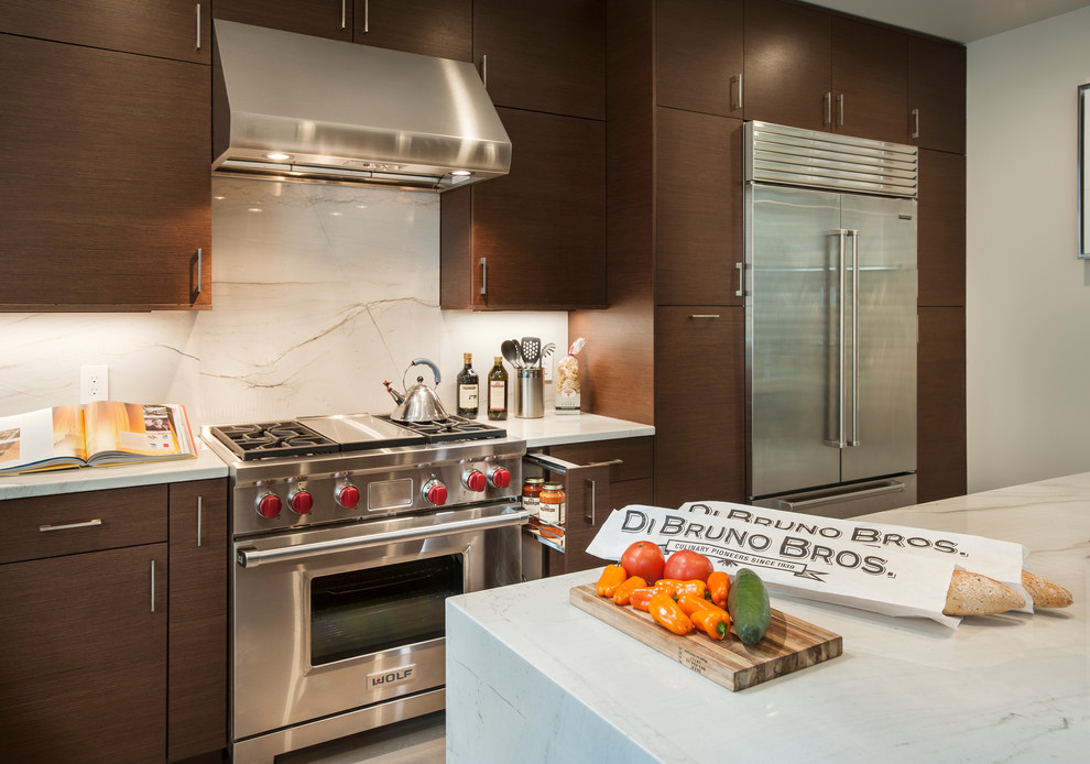 Example of a large trendy l-shaped light wood floor and beige floor kitchen design in Philadelphia with an undermount sink, flat-panel cabinets, dark wood cabinets, marble countertops, white backsplash, marble backsplash, stainless steel appliances and an island