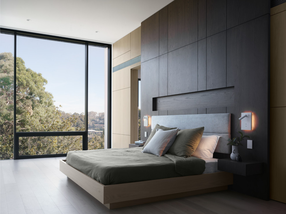 Design ideas for an expansive modern master bedroom in Sydney with light hardwood floors, beige floor and brown walls.